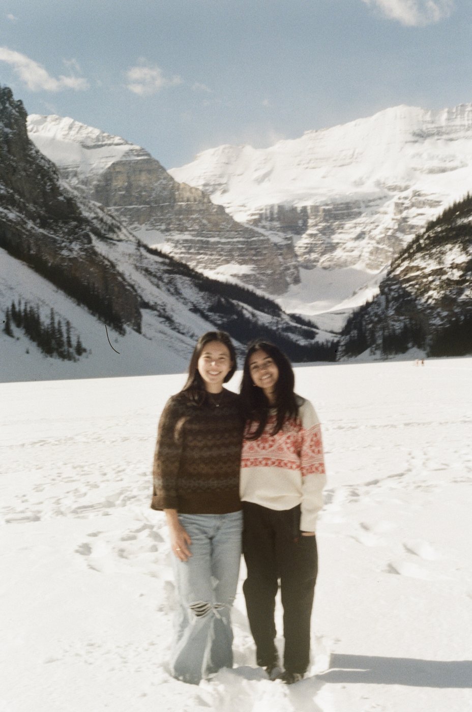 Two friends standing on the frozen lake at Lake Louise