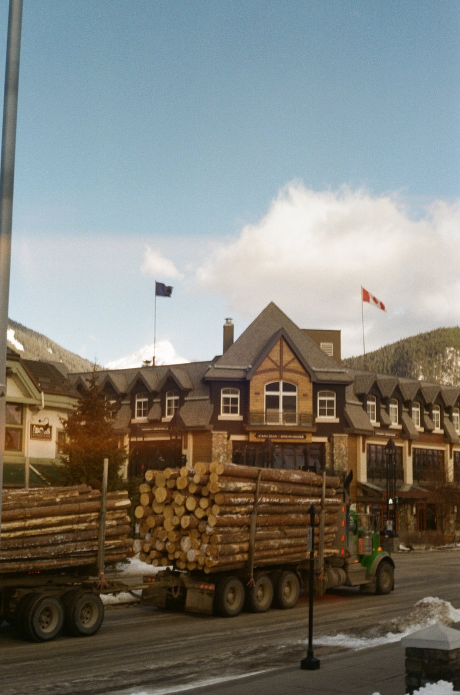 A logging truck parked outside a lodge in town