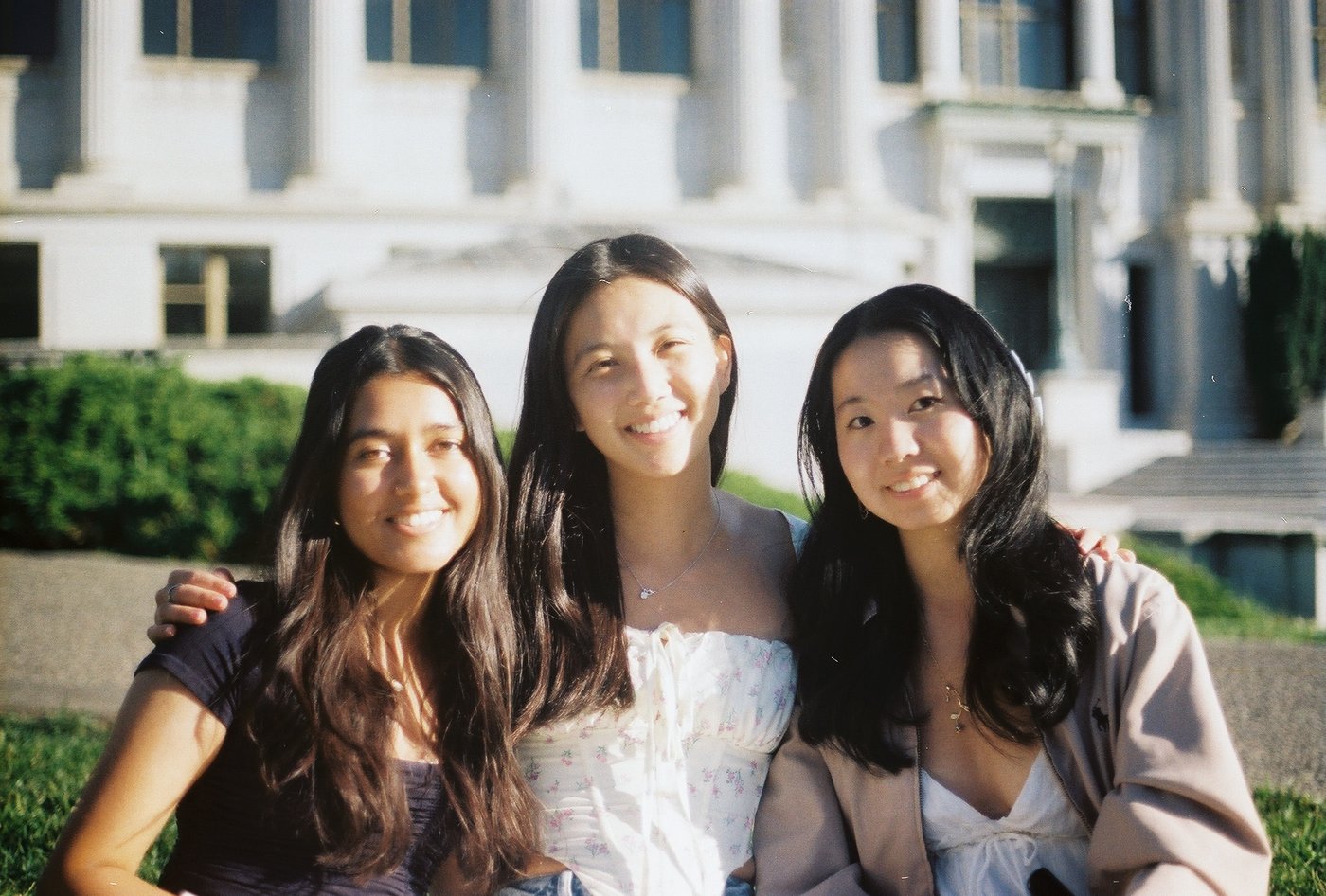Three friends posing in front of a building