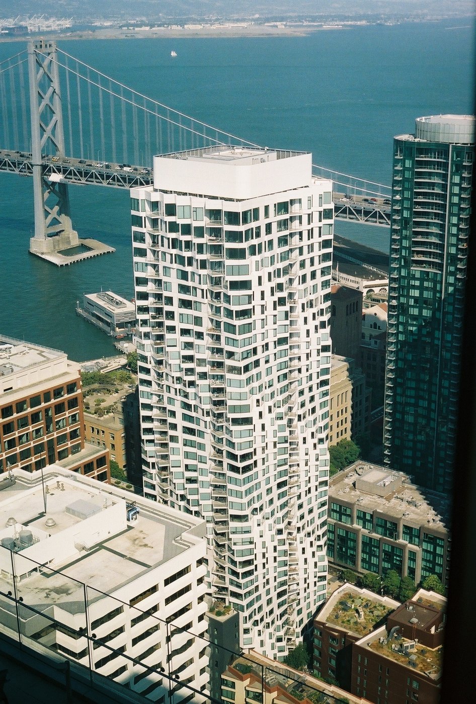 A high-rise and the Bay Bridge seen from above