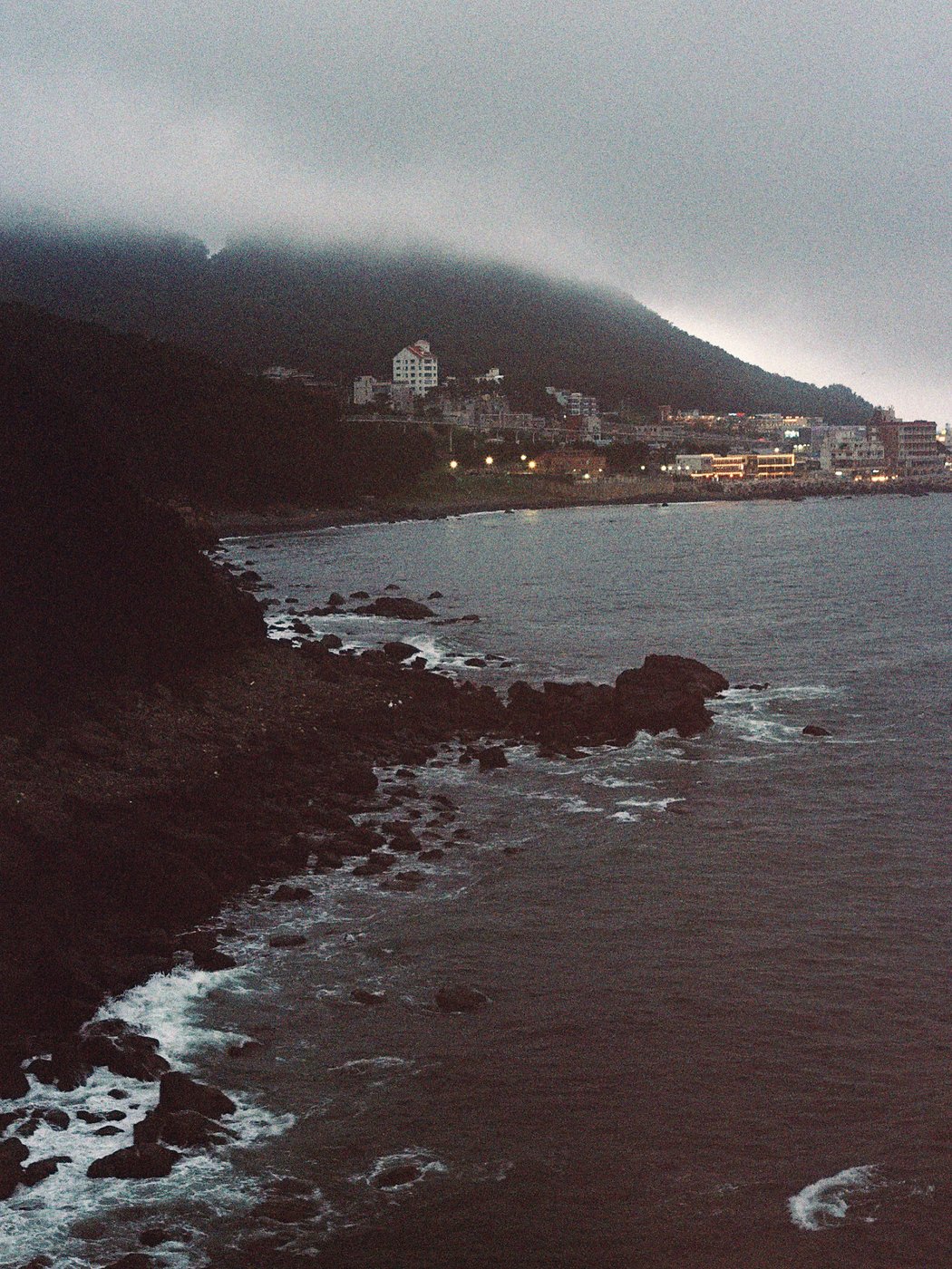 Foggy coastal cliffs and a hillside town