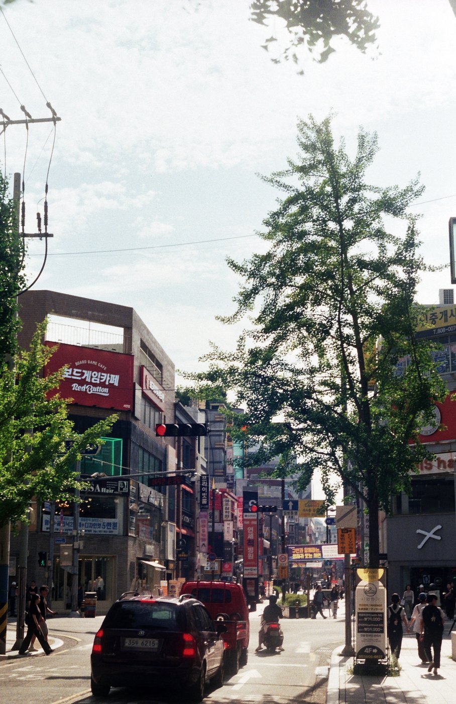 A city street lined with trees and shops