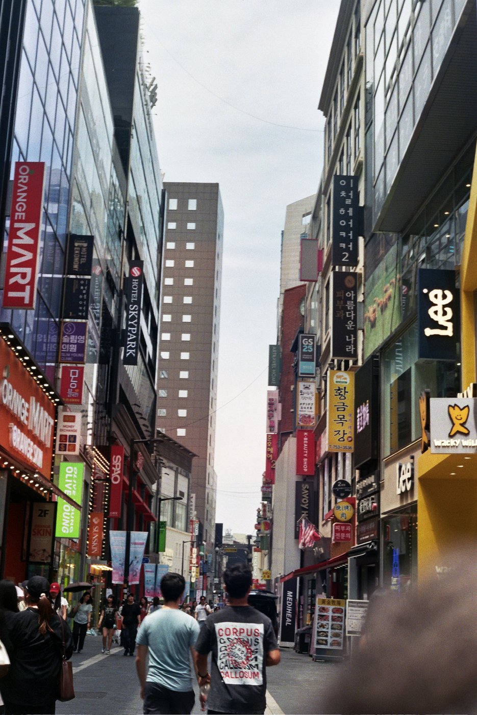 A busy shopping street with neon signs