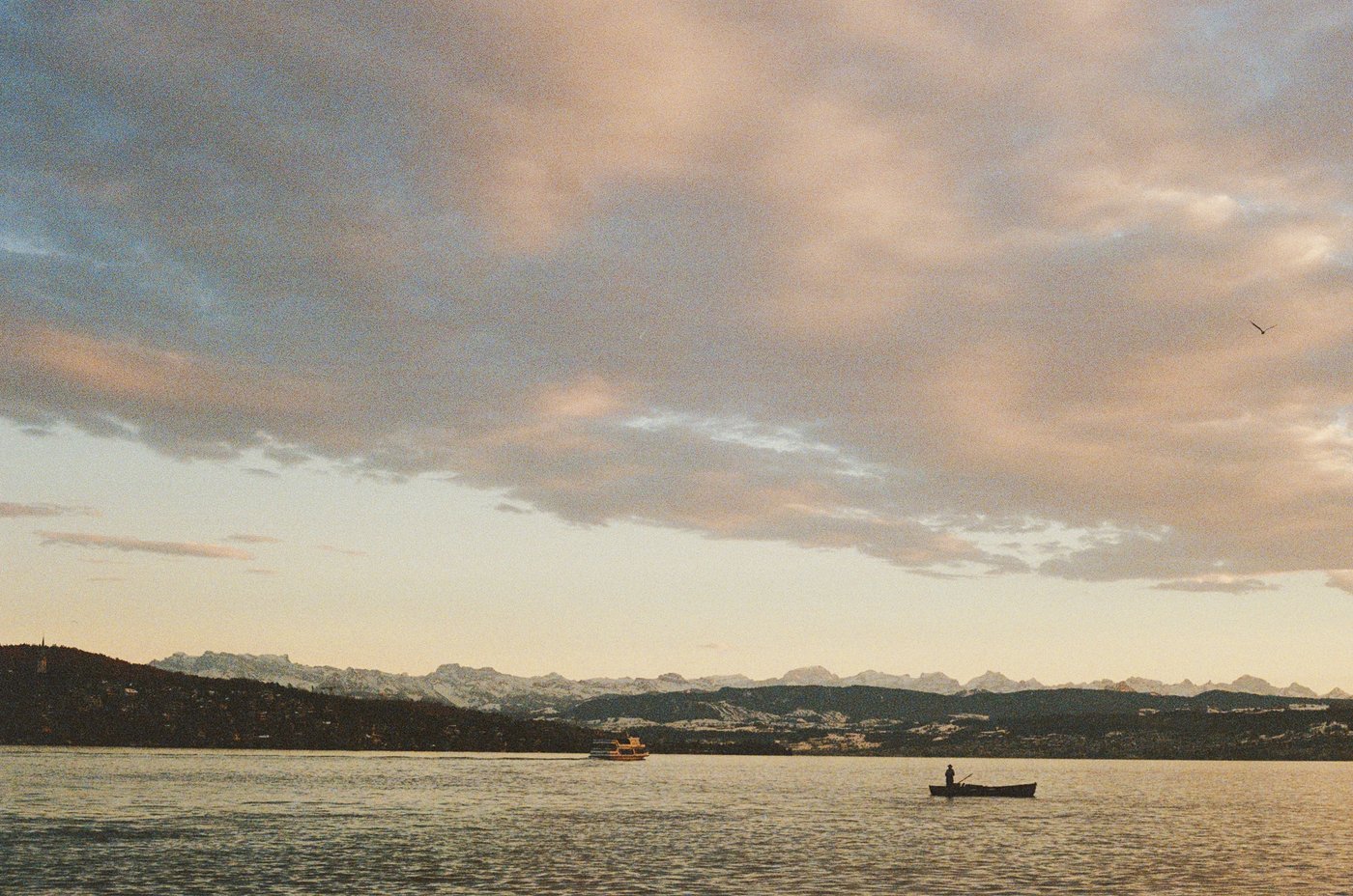 Sunset over a lake with a small boat