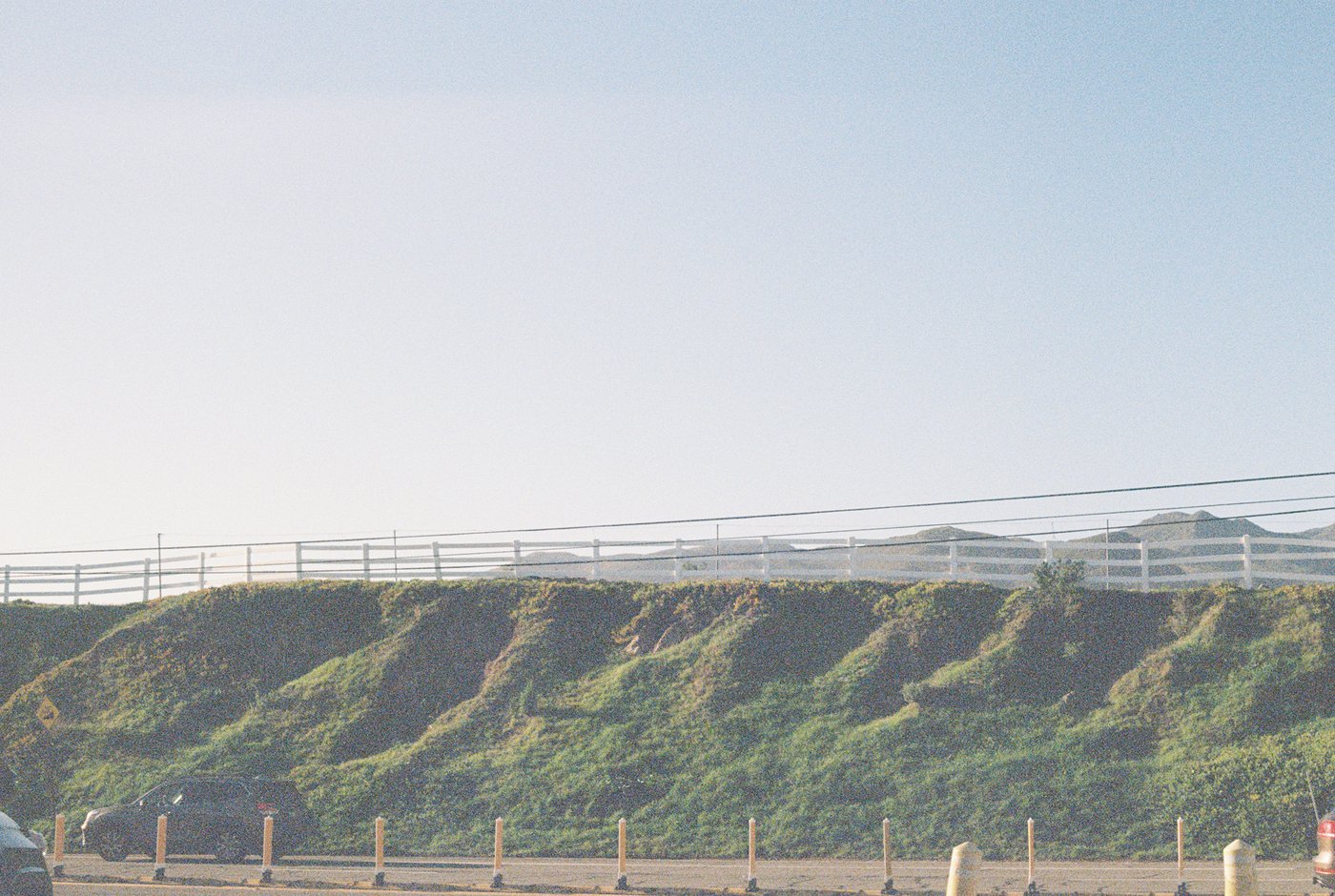 A grassy coastal bluff with a railing