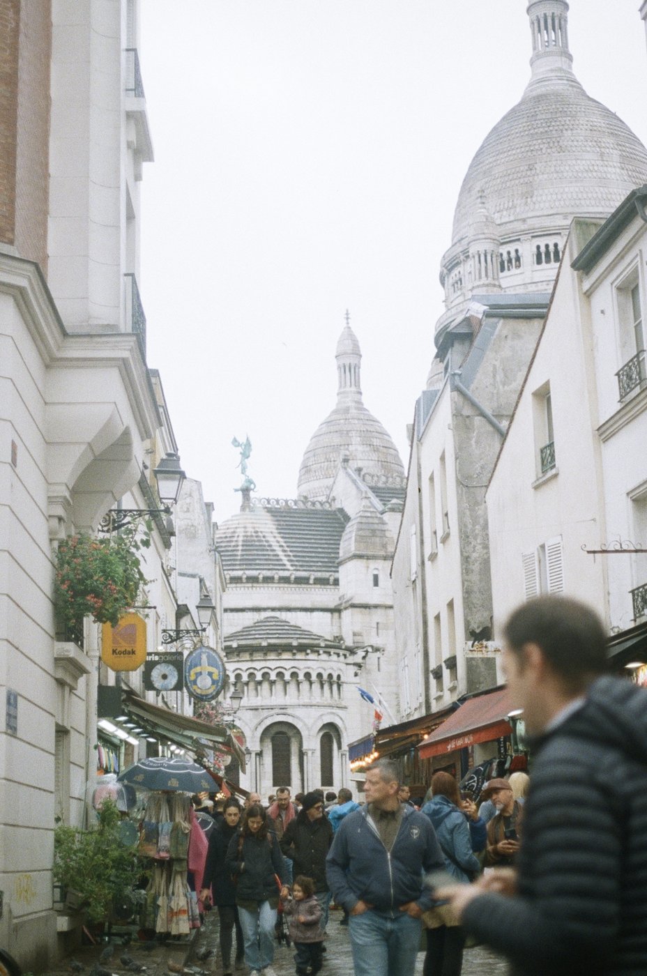 A street in Montmartre with the Sacré-Cœur dome in the distance